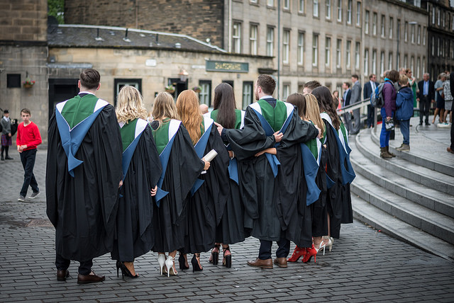A row of 33Ƶ graduands standing in a row wearing their gowns outside Usher Hall
