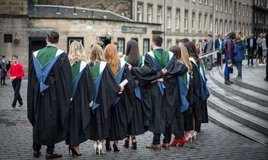 A row of 33Ƶ graduands standing in a row wearing their gowns outside Usher Hall