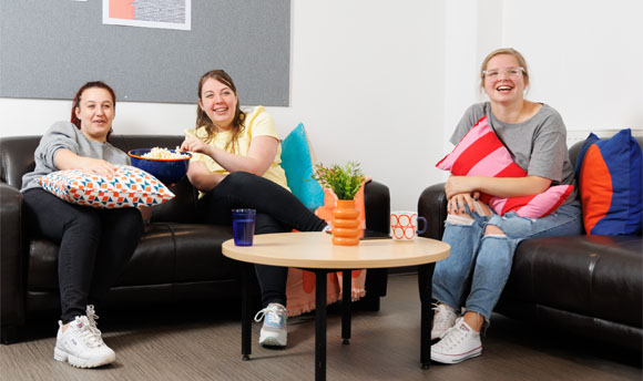 Three female students enjoy popcorn while watching a film in their 33Ƶ Student Accommodation